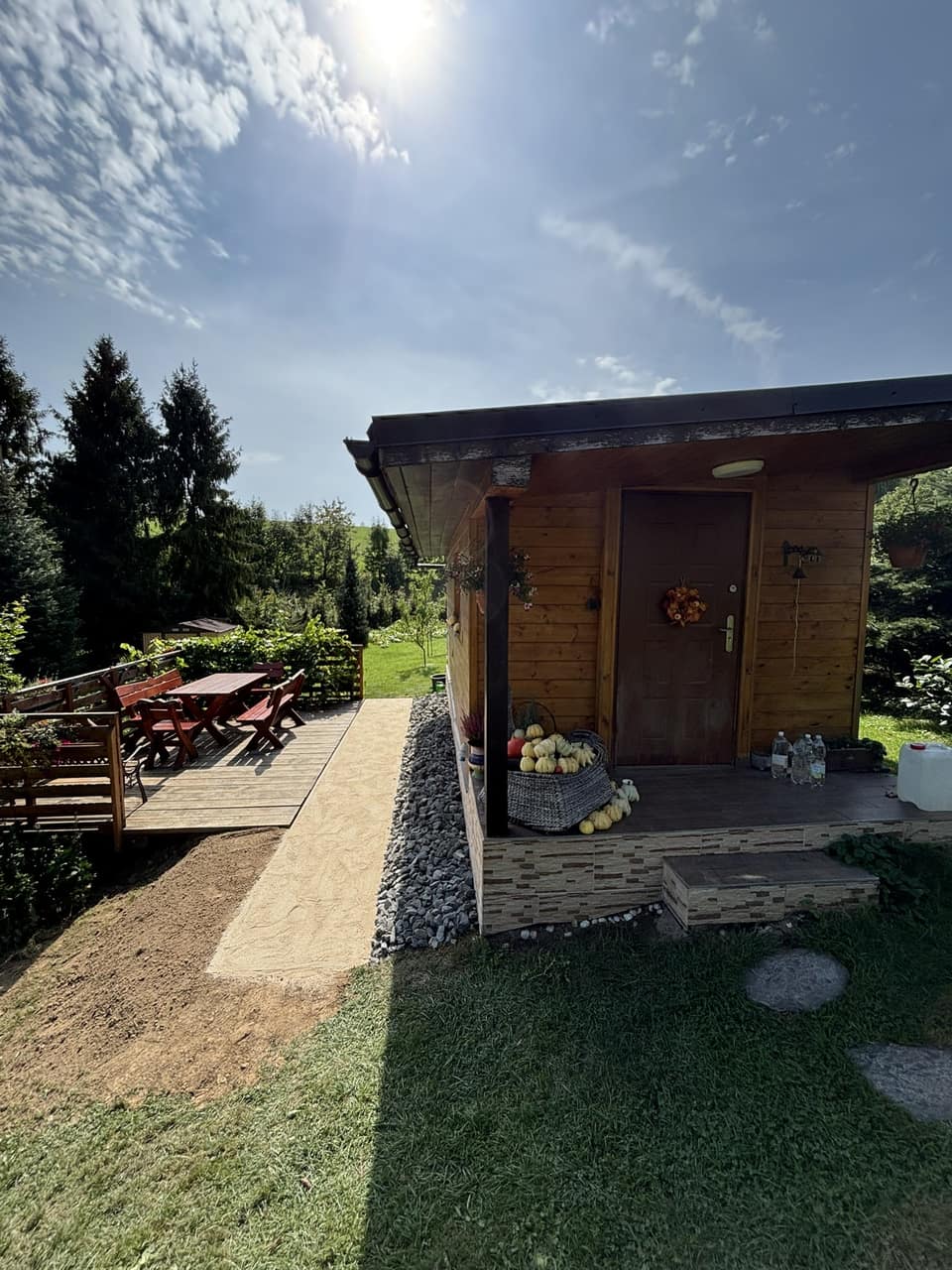 Hotový chodník s obrubníky podél dřevěné chaty a terasy