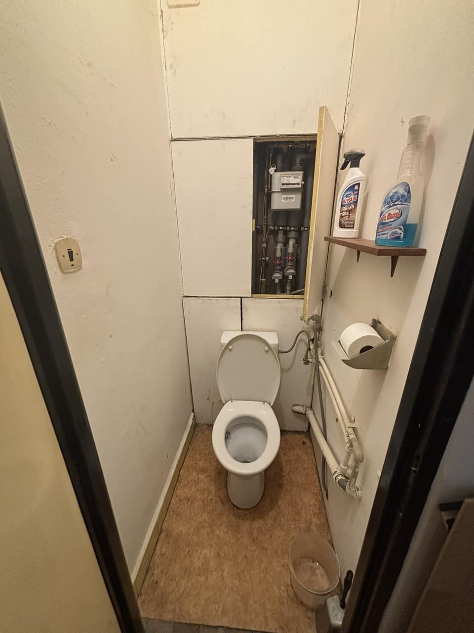Před: WC před rekonstrukcí: původní toaleta a dvířka k rozvodům