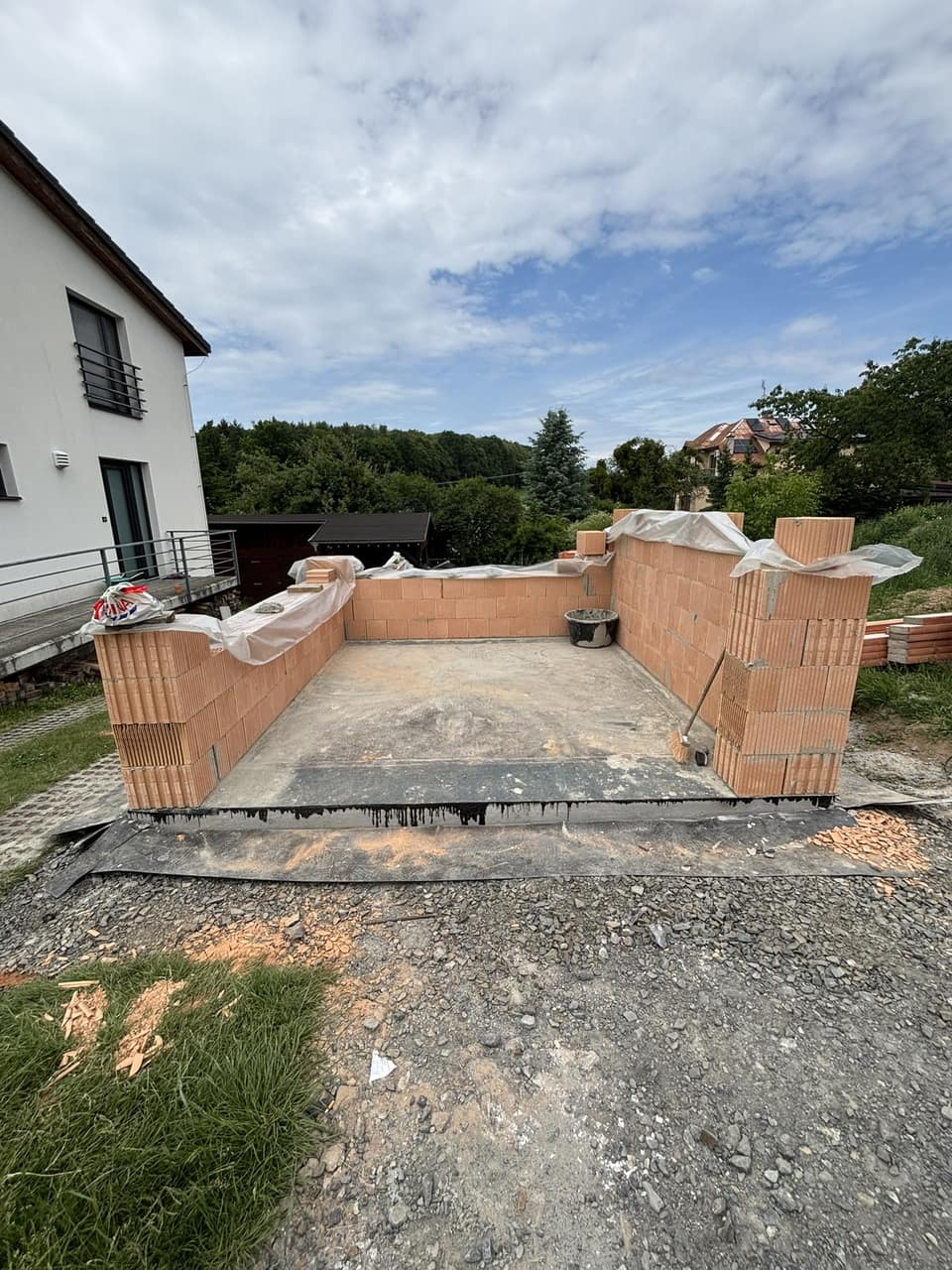 Rostoucí obvodové zdivo z cihel HELUZ vedle stávajícího domu ve Skalici