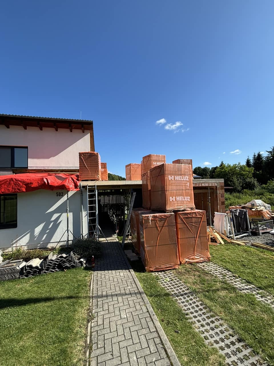 Palety s cihlami HELUZ připravené u stavby ve Skalici
